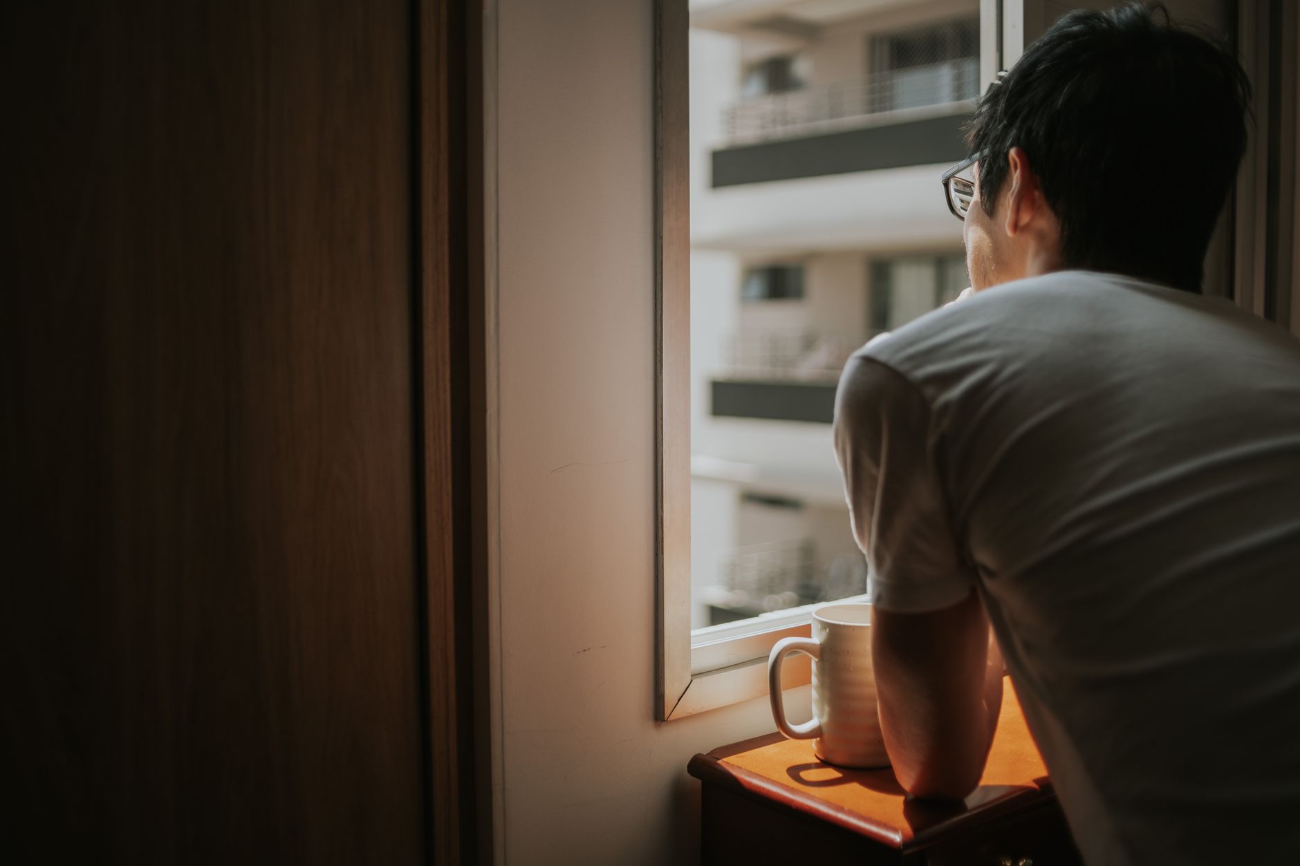 A person taking a quiet moment by a window