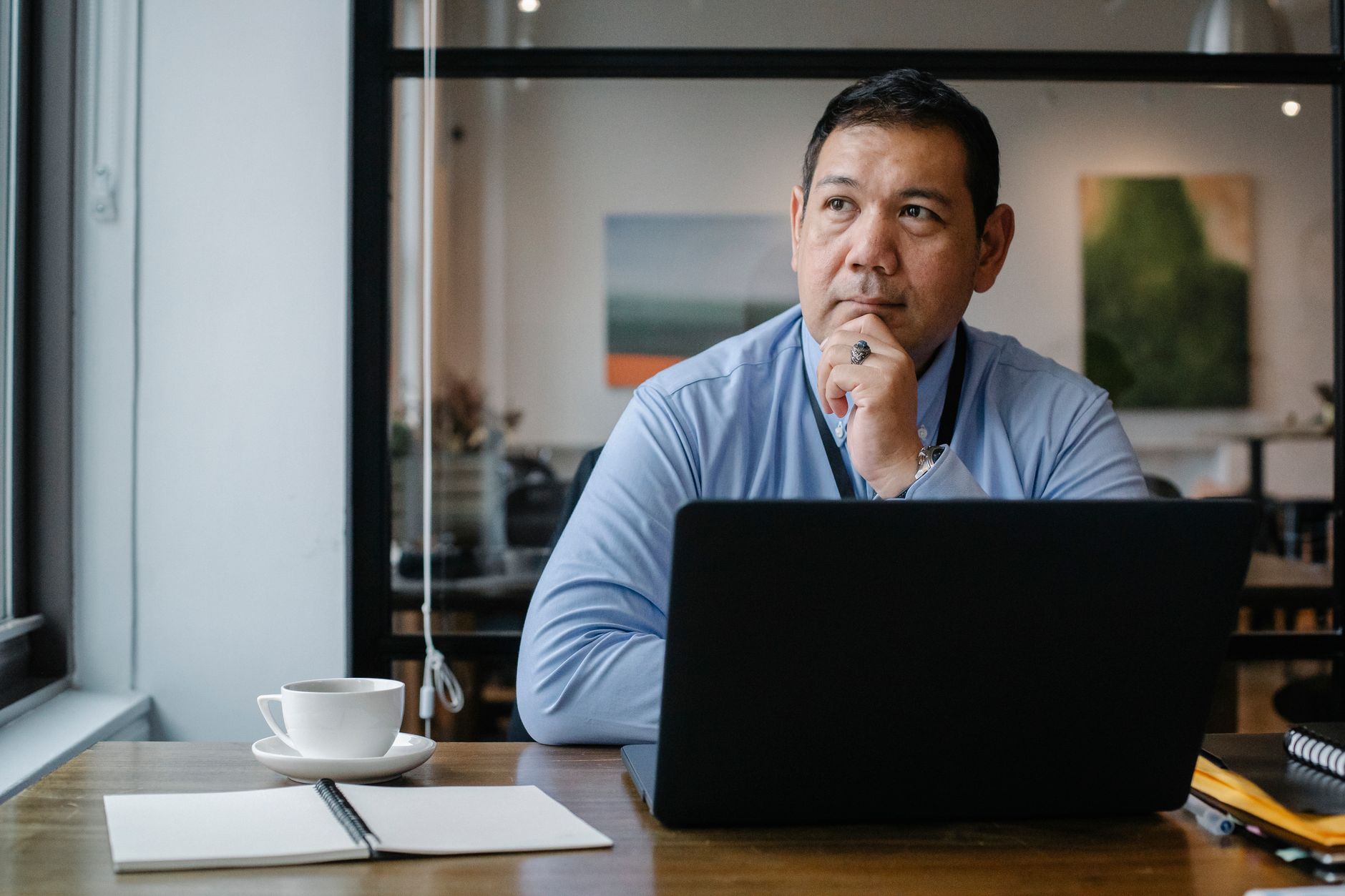 A person pausing to think at a laptop